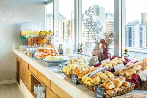 a buffet line with various types of bread and pastries at Salvador Business & Flat by Avectur in Salvador