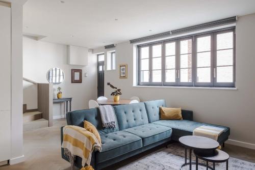 a living room with a blue couch and a table at Stunning 2-Bed Mews House with AC near Regent's Park in London