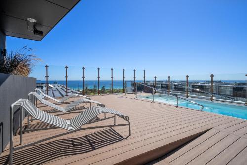 Una terraza con dos sillas y una piscina. en Fremantle Coast Studio Beach at your Doorstep, en North Fremantle