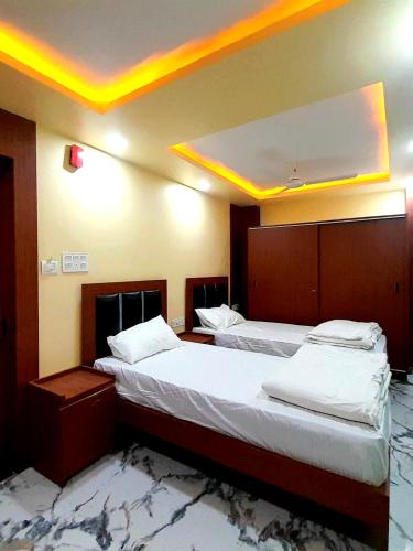 two beds in a room with lights on the ceiling at Hotel THE PRINCE Bodh Gaya Near Temple & The Great Buddha Statue Fully Air Conditioning Rooms in Bodh Gaya