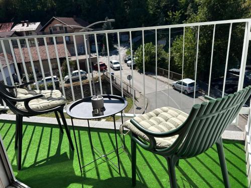 a balcony with two chairs and a table and a street at CENTRAL POINT APARTMENT - City centar Zenica- in Zenica