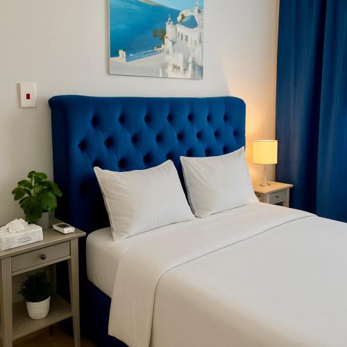a bed with a blue headboard in a room at شقة 7 هادئة بتصميم انيق ثلاث غرف ودخول ذاتي in Al Khobar