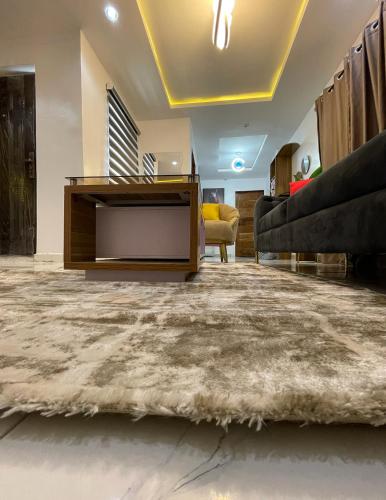 a living room with a television and a couch at Cozy Court Apartment in Ifako