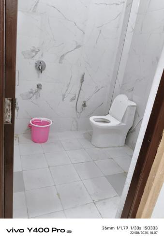 a bathroom with a toilet and a pink bucket at Hanu Guest house in Jaisalmer
