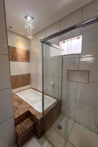 a bathroom with a shower with a tub at Casa aconchegante 2min do centro in Primavera do Leste