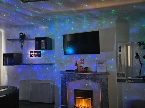 a living room with a fireplace and a ceiling with stars at Izabella apartment in Fort William in Fort William