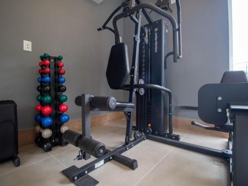 a room with a gym with a squat rack and balls at DOM Barra Hotel in Rio de Janeiro