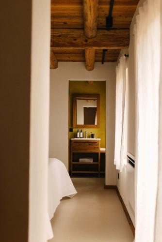 a hallway with a bathroom with a sink and a mirror at La Ghiandaia Farmhouse in Scomigo