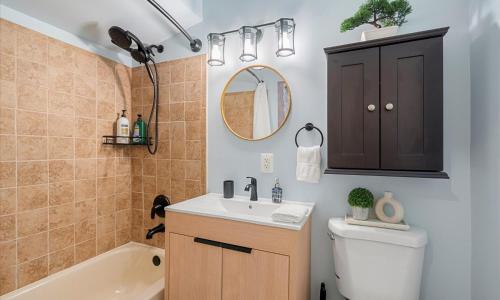 ein Badezimmer mit Waschbecken, Toilette und Spiegel in der Unterkunft The Emerald Grand Old Town Views in Belle Haven