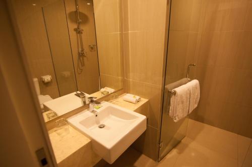 y baño con lavabo y ducha con espejo. en Amed Dream Resort en Amed