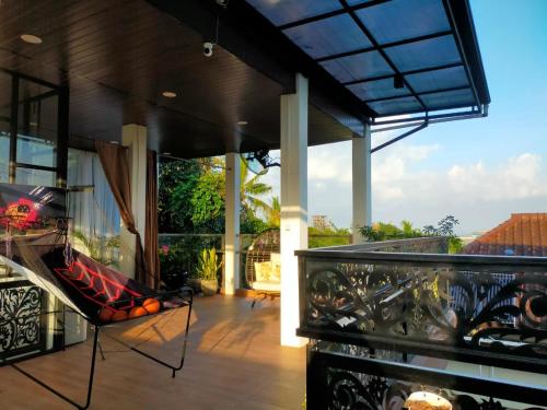 a balcony of a house with a chair on it at Guest House Adiwinoto in Mantaak