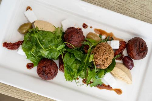 a plate of food with meatballs and greens on it at Grand Hotel Swanage in Swanage