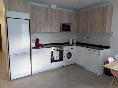 a kitchen with a stove and a washing machine at Ca l'Emília, hasta 6 pers, Monistrol de Montserrat in Monistrol