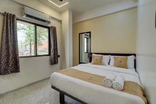 a bedroom with a large bed with towels on it at Krishna Residency in Navi Mumbai