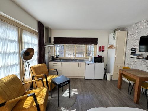 a living room with a kitchen and a table at Appartement Villa Eva Rosa in Wijk aan Zee