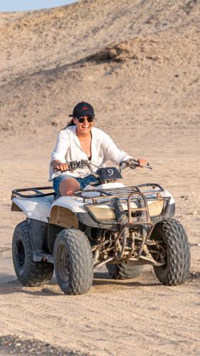 a woman riding a four wheeler in the desert at Marsa Shagra Village in Abu Dabab