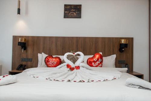 a white bed with two red hearts on it at AXIL HÔTEL in Dakar