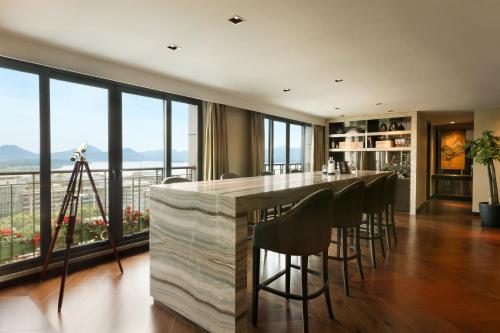 a kitchen with a bar with black chairs and windows at Midtown Shangri-La, Hangzhou - around 5 minutes walking distance to West Lake in Hangzhou