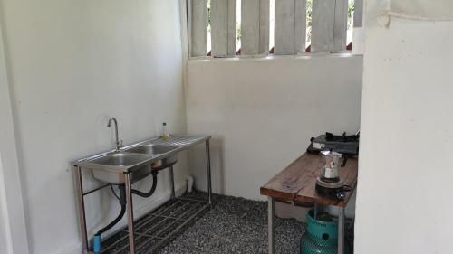a bathroom with a sink and a window at Yut Homestay in Pang Ung