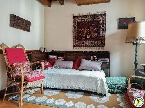 a bedroom with a bed and two chairs and a rug at Au village in Boutx