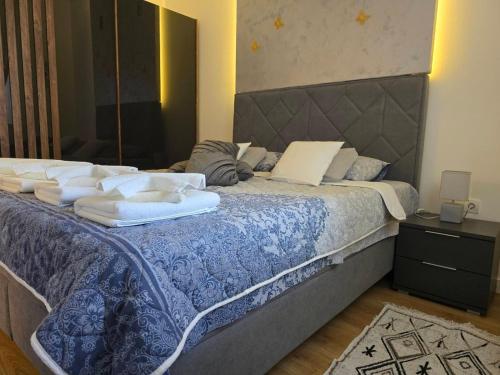 a bedroom with a large bed with towels on it at Apartman Marjanović Palić in Palić