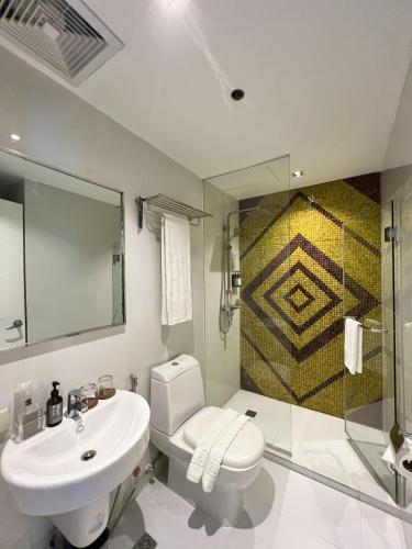 a bathroom with a toilet and a sink and a shower at KL Serviced Residences Managed by HII in Manila
