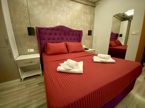 a bedroom with a red bed with towels on it at Deluxe Vista Suit Hotel Taksim in Istanbul