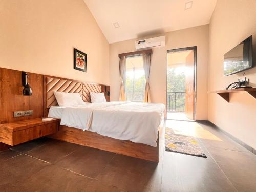 a bedroom with a bed and a television in it at Unwind Karjat in Palasdhari