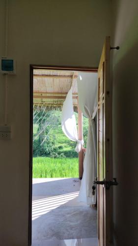 an open door with a wedding dress in a doorway at Yut Homestay in Pang Ung