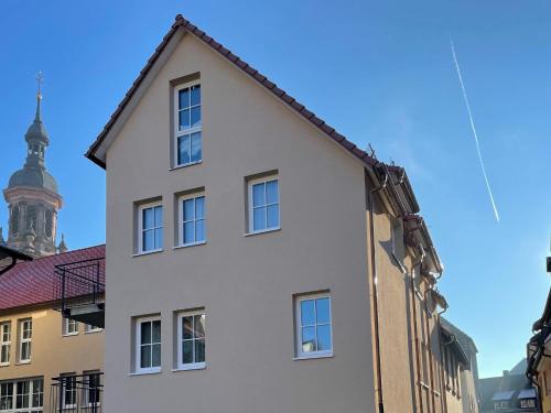 a white building with a tower in the background at Ferienwohnungen St Marien in Gengenbach