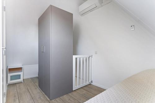 a bedroom with a large gray cabinet next to a bed at Weststraat 22 - Ouddorp - Appartement Oost 3P in Ouddorp