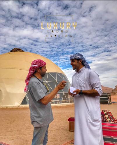 two men are standing in front of a tent at RUM CROWD DARLiNG LUXURY in Wadi Rum