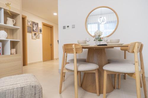 a dining room table with a mirror and two chairs at Stylish 2BR - Chic Elegant Urban Escape in Abu Dhabi