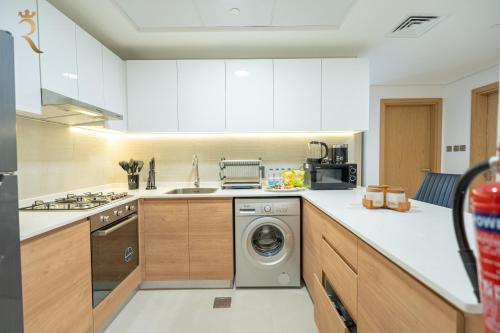 a kitchen with a washing machine and a sink at Stylish 2BR - Chic Elegant Urban Escape in Abu Dhabi