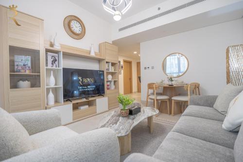 a living room with a couch and a tv at Stylish 2BR - Chic Elegant Urban Escape in Abu Dhabi