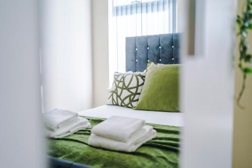 a bed with towels on top of it with a window at Stylish & Delightful 3BD Family Home - Near Coop Live & Etihad Stadium - Free Parking - Unlimited high speed WiFi in Manchester