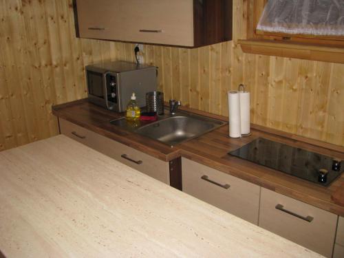 a kitchen with a sink and a microwave at Domki Letniskowe ARKON in Strykowo