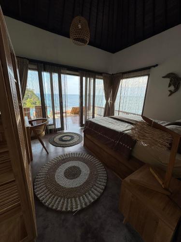 a bedroom with a bed and a view of the ocean at Makawi Tuwa in Seraya