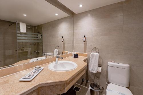 a bathroom with a sink and a toilet and a mirror at Seven Seas Jolie Bay - Ultra All Inclusive in Hurghada