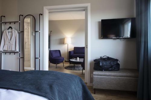 - une chambre avec un lit, une télévision et une chaise dans l'établissement Scandic Aalborg Øst, à Aalborg