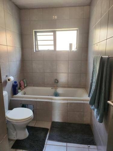 a bathroom with a tub and a toilet and a sink at Ryder Masai Lofts in Farmall