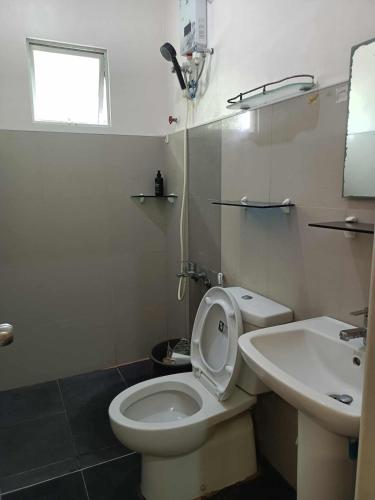 a bathroom with a white toilet and a sink at Joel's House in Iloilo City