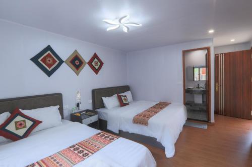 a hotel room with two beds and a mirror at Sapa Succulent Garden Homestay in Sa Pa