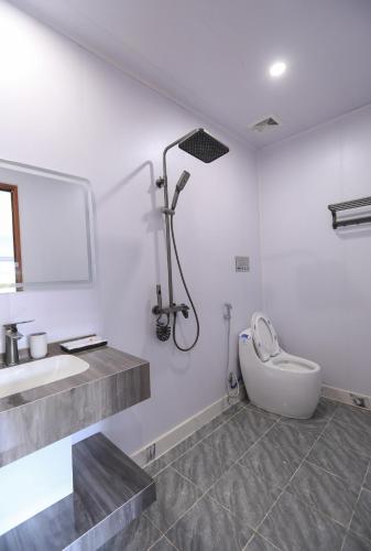 a white bathroom with a sink and a toilet at Sapa Succulent Garden Homestay in Sa Pa