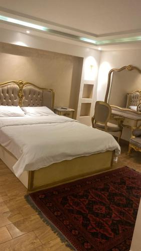a bedroom with a large bed and a desk at H&d abrrtment hotel 5 in Cairo
