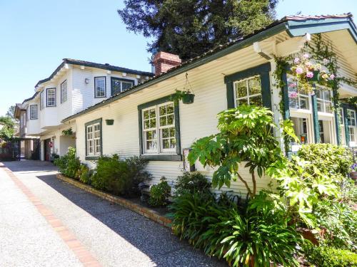 a white house with windows and plants on a street at Briarwood Inn in Carmel