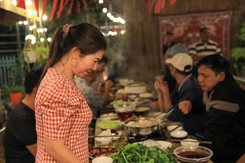 a woman standing in front of a table of food at Sapa Succulent Garden Homestay in Sa Pa