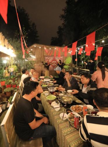 a group of people sitting at a table eating food at Sapa Succulent Garden Homestay in Sa Pa