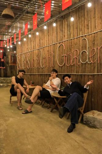 a group of men sitting on a wooden bench at Sapa Succulent Garden Homestay in Sa Pa