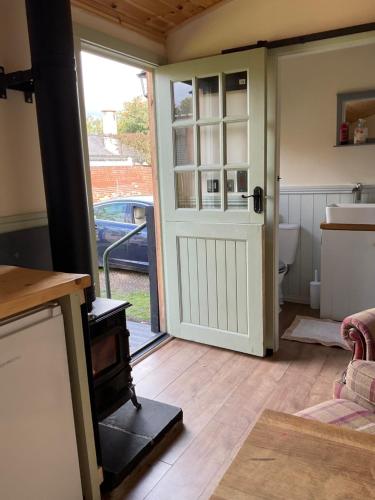 a kitchen with a door leading to a bathroom at Shepherds Hut at The Old School House in Durham
